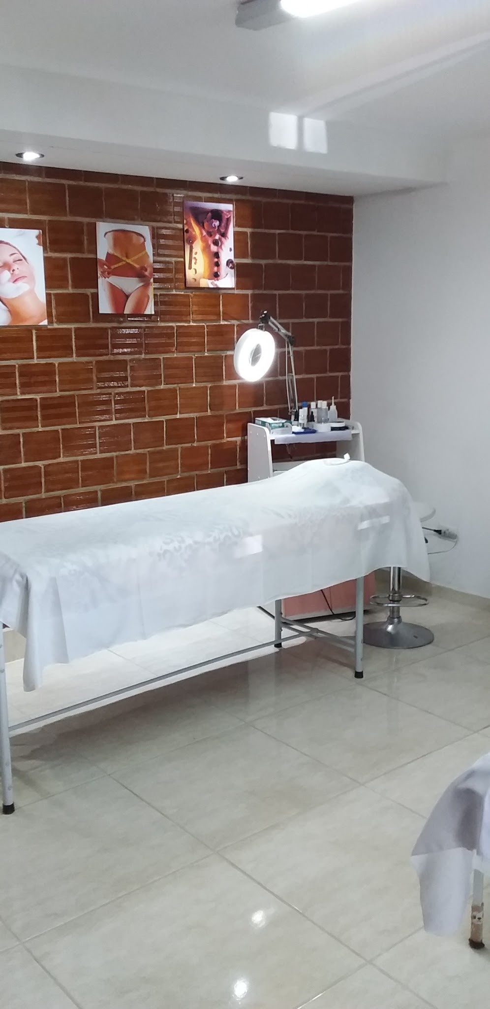 Sala com maca e parede de tijolinho