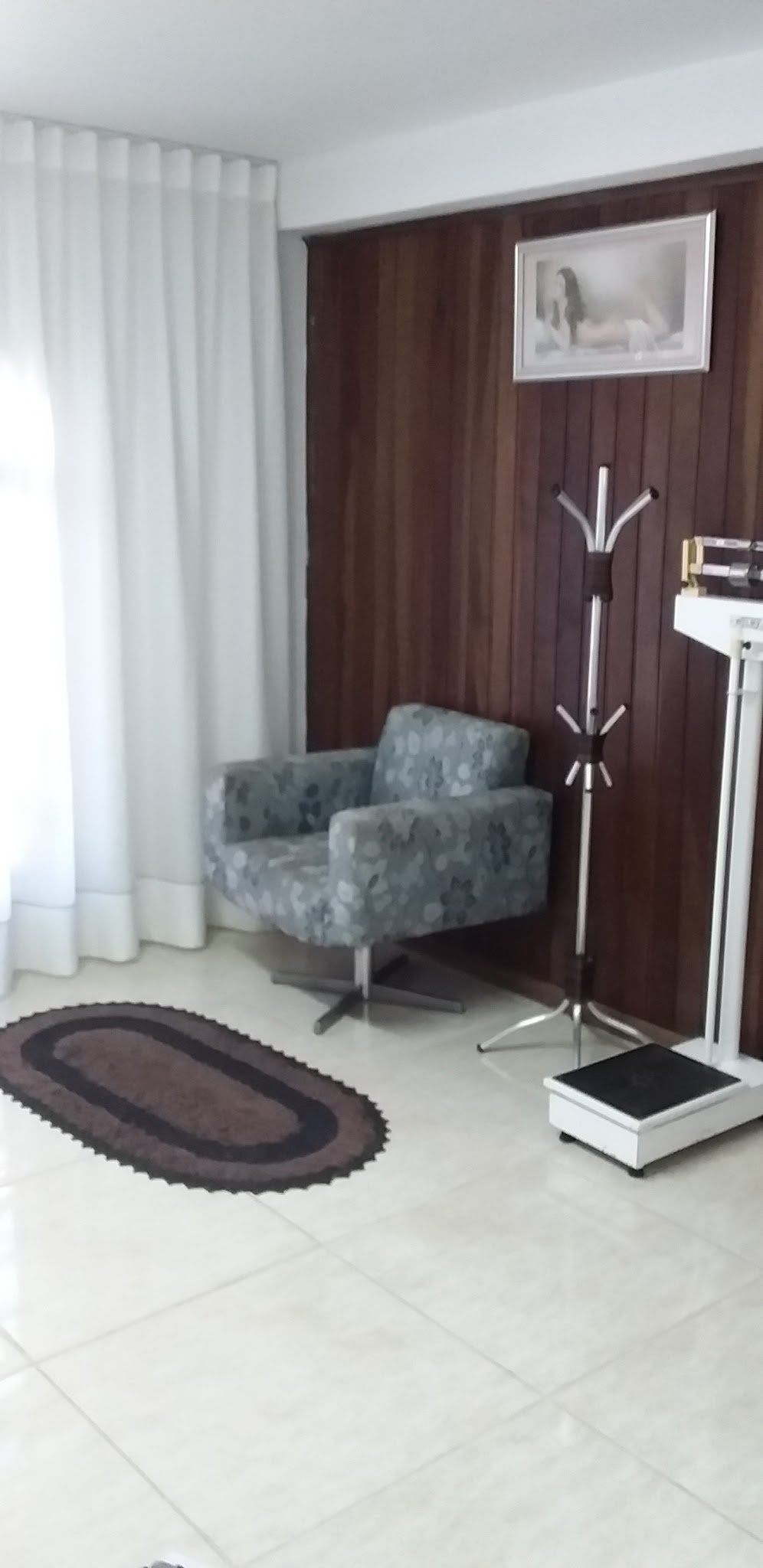 Sala de atendimento com poltrona e cortinas